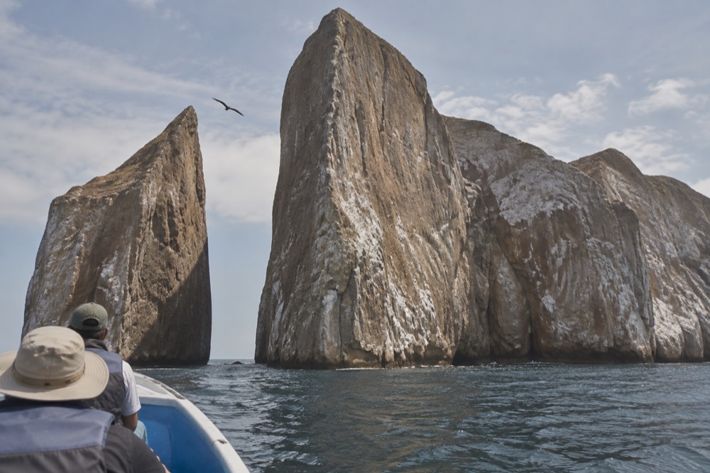 Kicker Rock off San Cristobal in the Galapagos Islands, its tuff walls streaked ochre and grey in late-morning haze, crumbly ash slopes catching light
