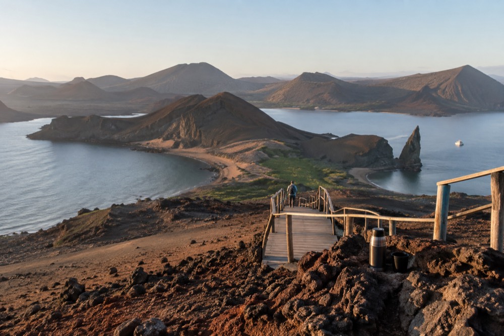 Seven in the morning in the Galapagos Islands, Ecuador: low golden light rakes a barren volcanic cone of rust-red scree and pale ash