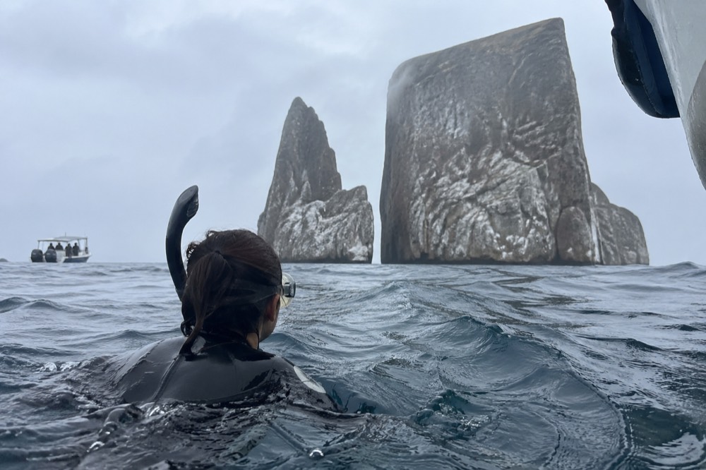 Kicker Rock towering soft behind off San Cristóbal, Galapagos Islands, Ecuador; cool garúa-season haze, choppy water, a mask dripping